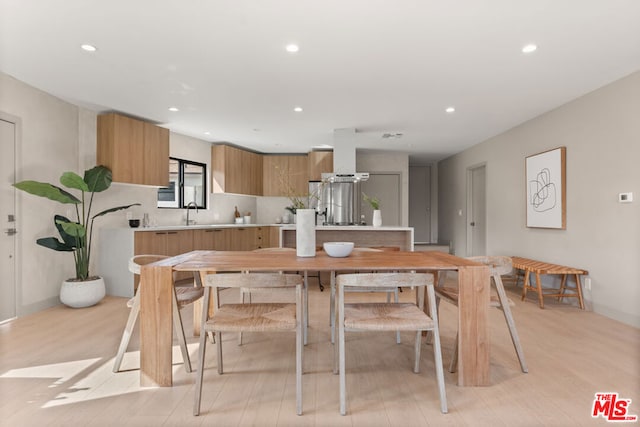 kitchen featuring backsplash, light hardwood / wood-style flooring, extractor fan, and sink