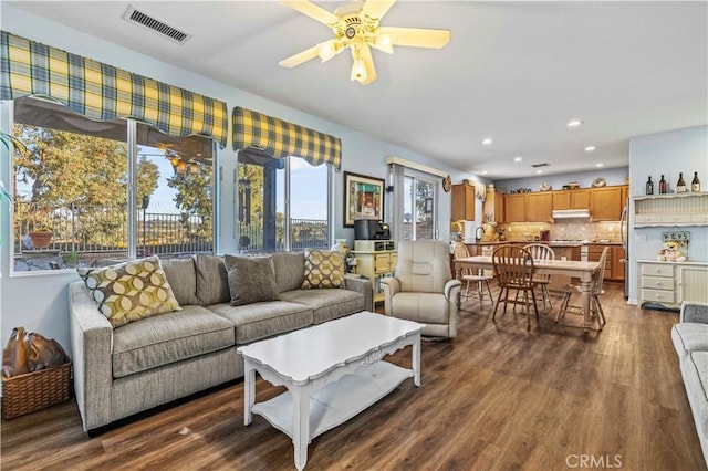 living room featuring ceiling fan and dark wood-type flooring