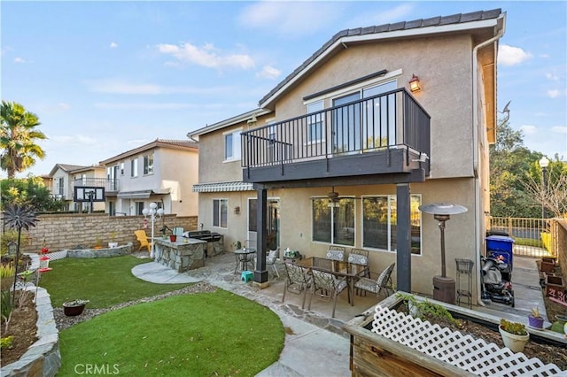 back of house with a balcony, a yard, and a patio