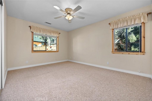 unfurnished room with ceiling fan, carpet floors, and a wealth of natural light