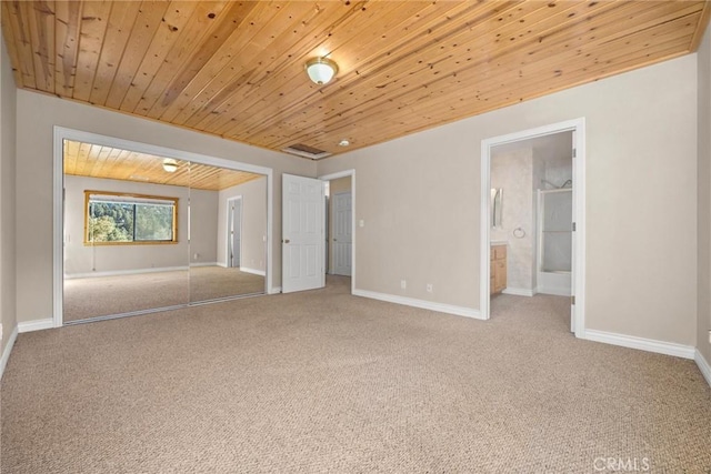 carpeted empty room featuring wood ceiling