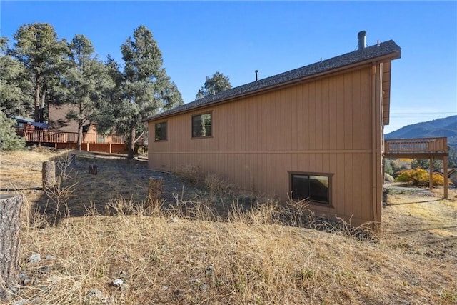 view of property exterior featuring a deck with mountain view