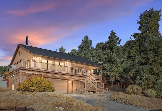 view of front facade featuring a wooden deck and a garage