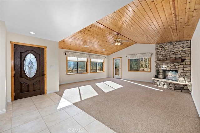 entryway with vaulted ceiling, light colored carpet, a stone fireplace, and wood ceiling