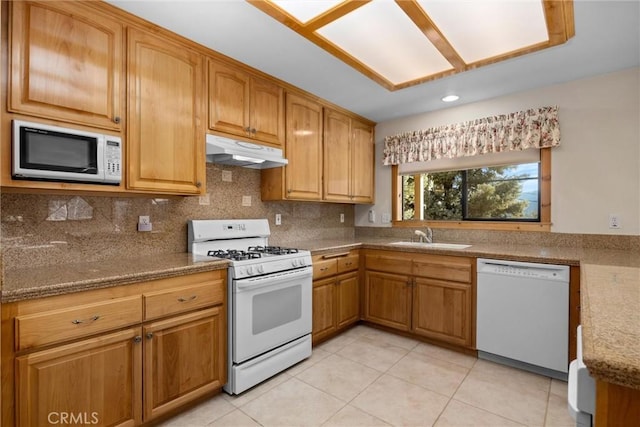 kitchen featuring sink, light stone counters, backsplash, white appliances, and light tile patterned floors