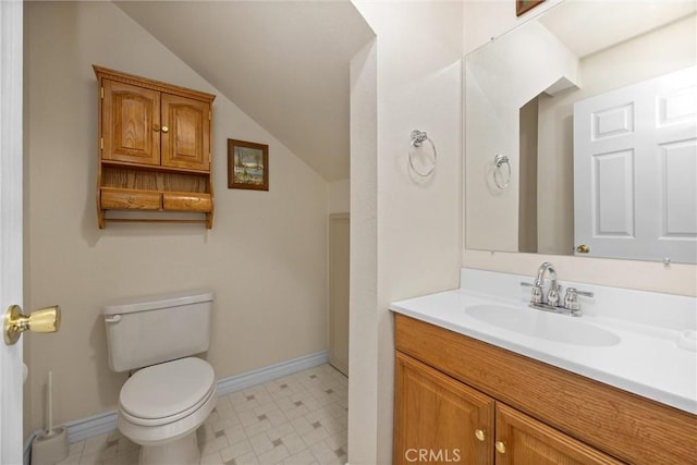 bathroom featuring vanity, toilet, and lofted ceiling