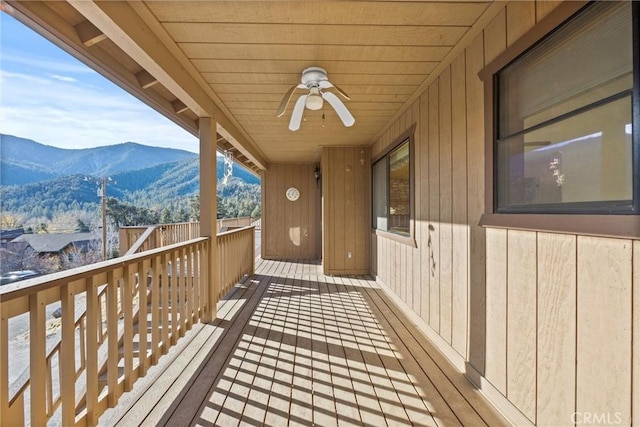 wooden terrace featuring a mountain view and ceiling fan