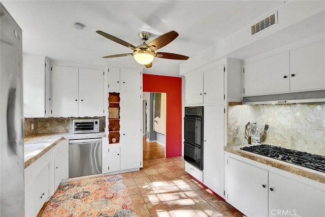 kitchen featuring backsplash, white cabinetry, light tile patterned floors, and appliances with stainless steel finishes