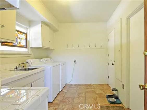 laundry room with cabinets, sink, and washer and dryer