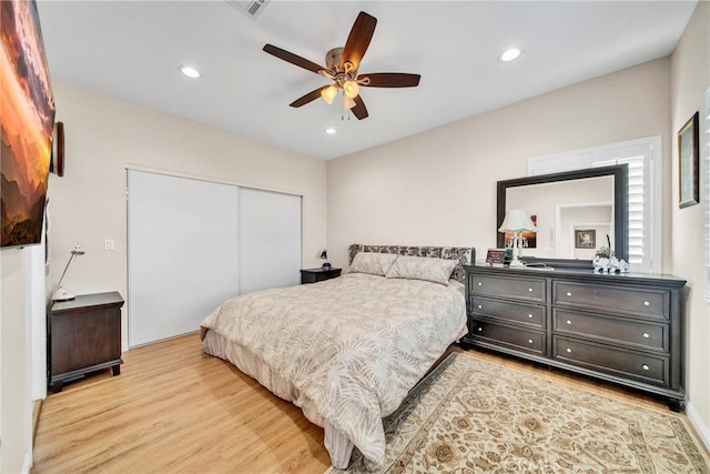 bedroom featuring light wood-type flooring, a closet, and ceiling fan