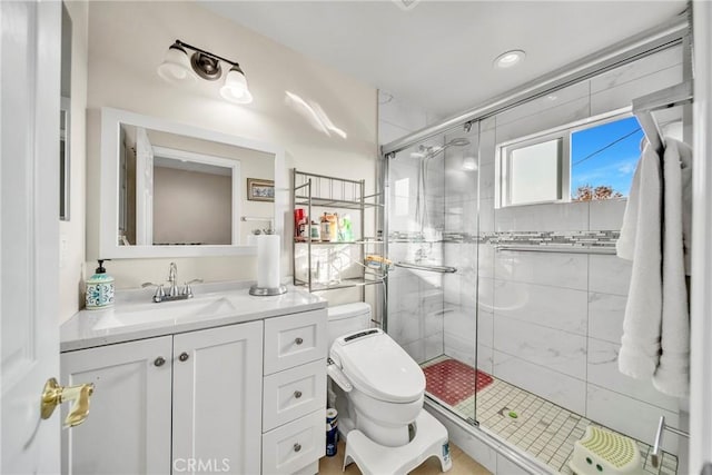 bathroom featuring toilet, vanity, and a shower with shower door