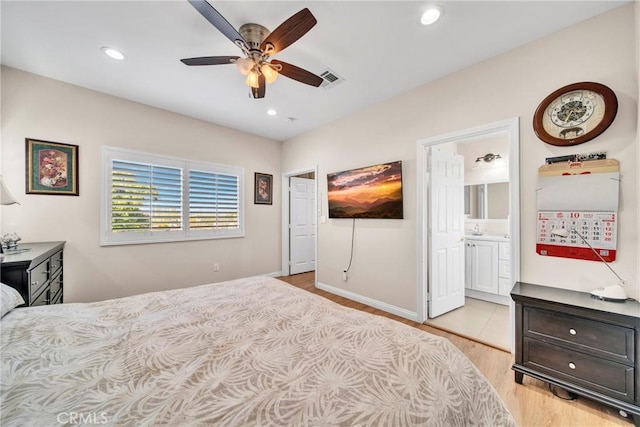 bedroom with light wood-type flooring, connected bathroom, and ceiling fan