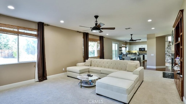 living room featuring ceiling fan and light colored carpet