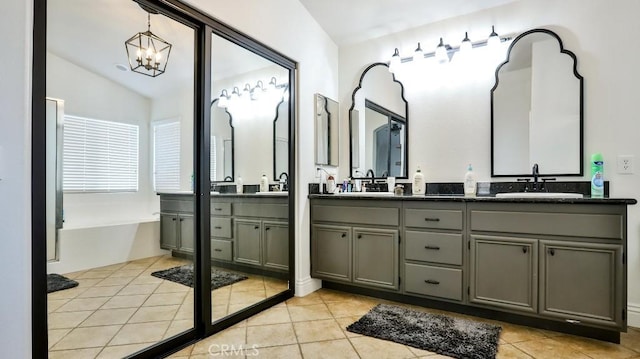 bathroom featuring tile patterned floors, vanity, a chandelier, and vaulted ceiling