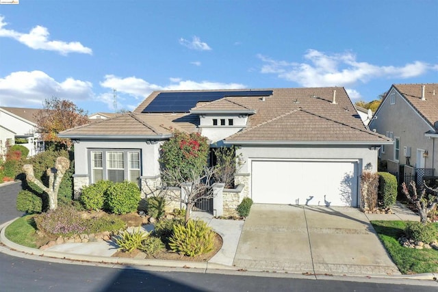 view of front of house featuring solar panels and a garage