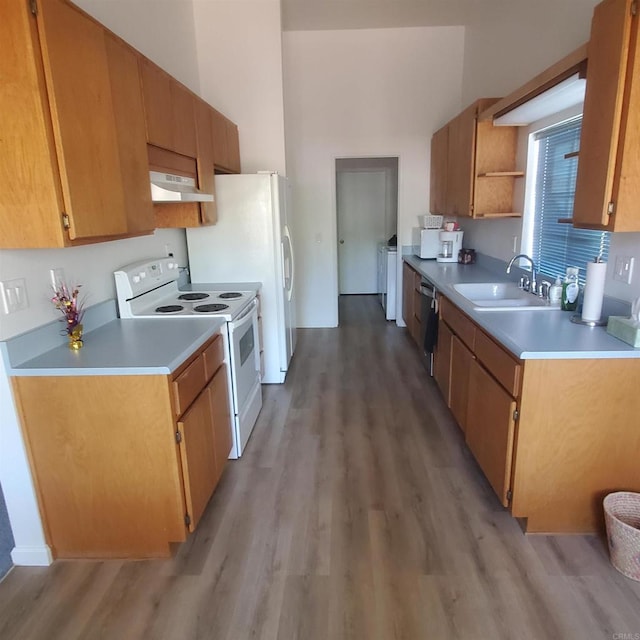 kitchen featuring sink, electric range, stainless steel dishwasher, light wood-type flooring, and washer / clothes dryer