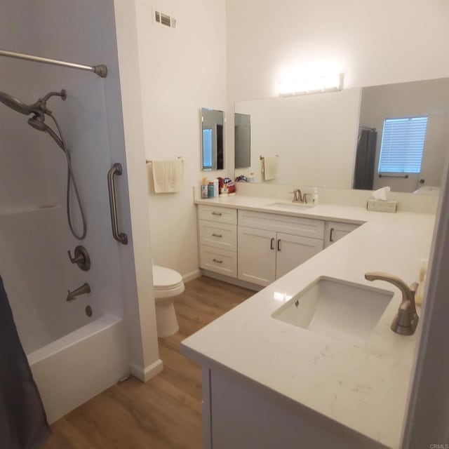 full bathroom featuring vanity, hardwood / wood-style floors, shower / bath combination with curtain, and toilet