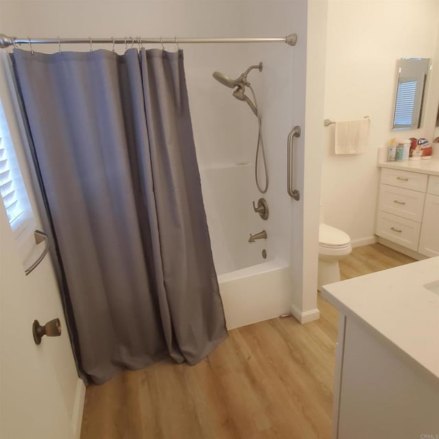 full bathroom with wood-type flooring, shower / tub combo, vanity, and toilet