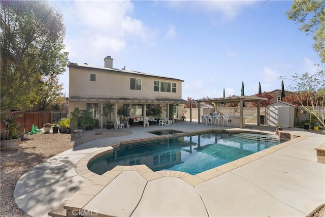 view of pool with a patio area, a shed, a bar, and an in ground hot tub