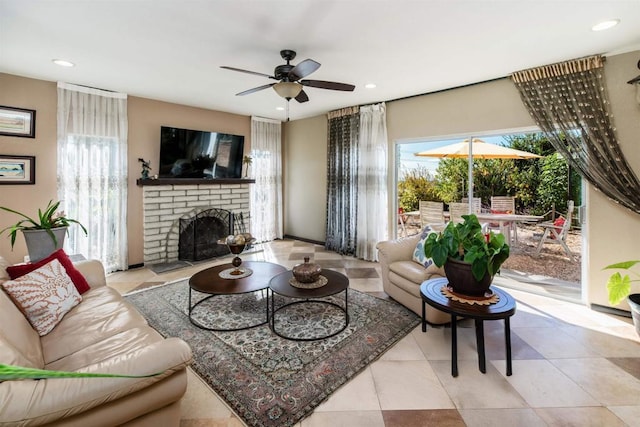 living room with ceiling fan, light tile patterned floors, and a brick fireplace