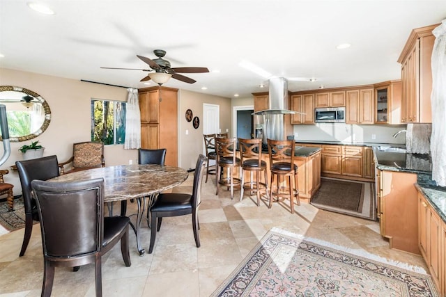 dining space with ceiling fan and sink