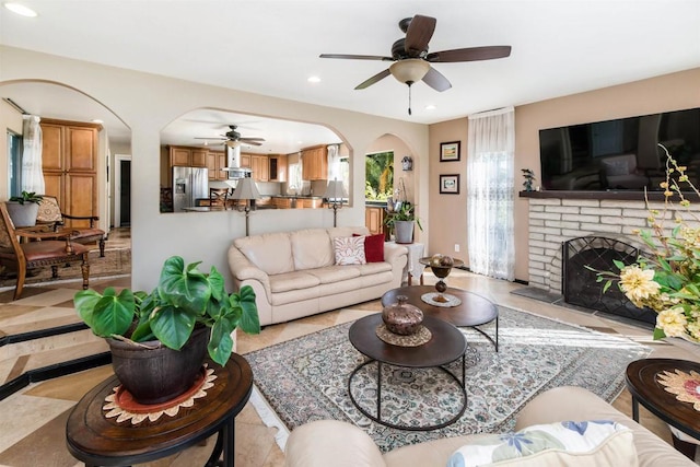 living room with a fireplace and ceiling fan