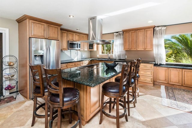 kitchen with a center island, dark stone counters, sink, appliances with stainless steel finishes, and island exhaust hood