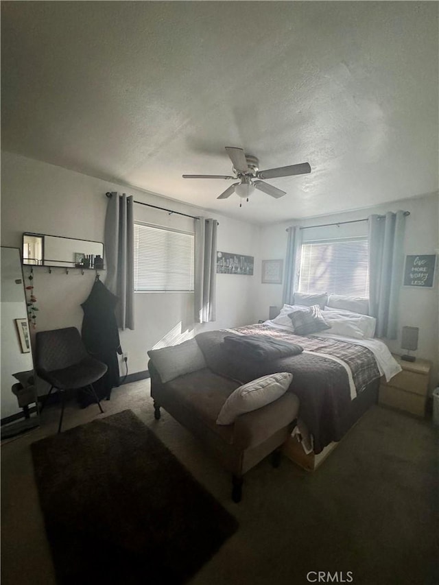 bedroom with ceiling fan, carpet, and a textured ceiling