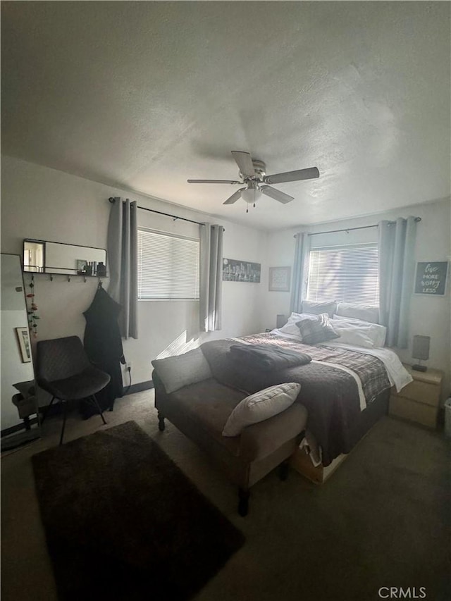 carpeted bedroom with ceiling fan and a textured ceiling