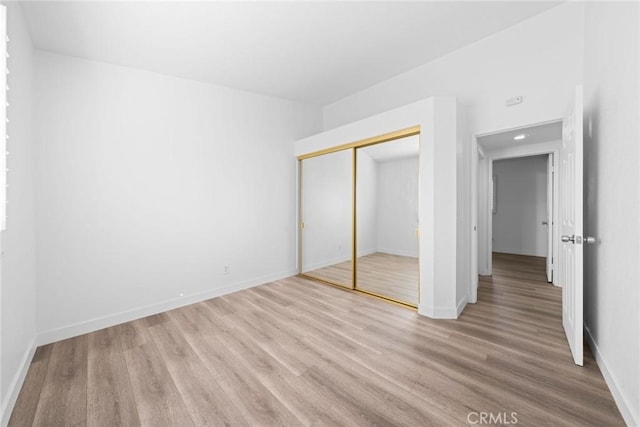 unfurnished bedroom with a closet and light hardwood / wood-style floors