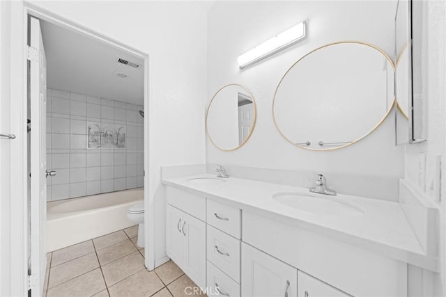 full bathroom with tile patterned flooring, vanity, tiled shower / bath combo, and toilet