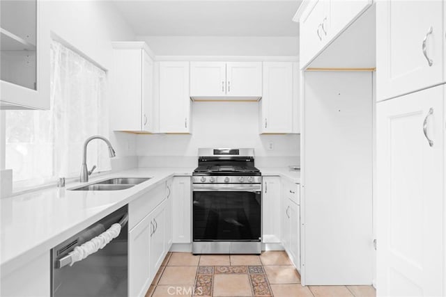 kitchen featuring light tile patterned flooring, stainless steel appliances, white cabinetry, and sink