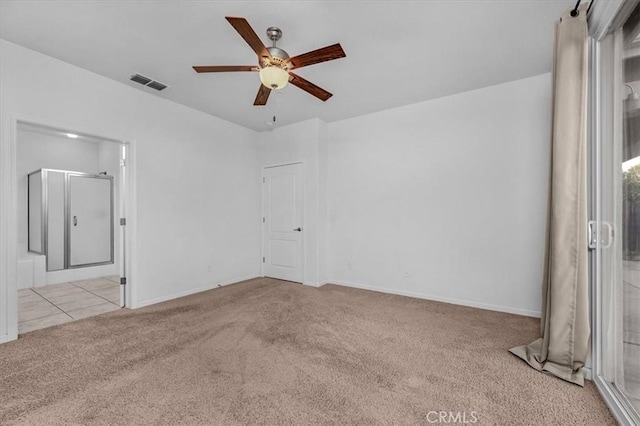 empty room featuring ceiling fan and light colored carpet