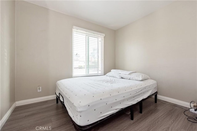 bedroom with baseboards and wood finished floors