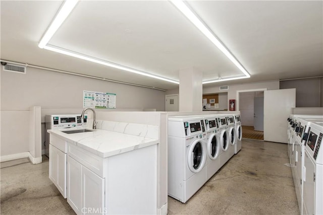 common laundry area featuring stacked washer and dryer, washer and clothes dryer, a sink, and visible vents