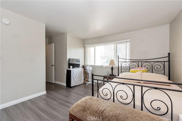 bedroom featuring baseboards and wood finished floors