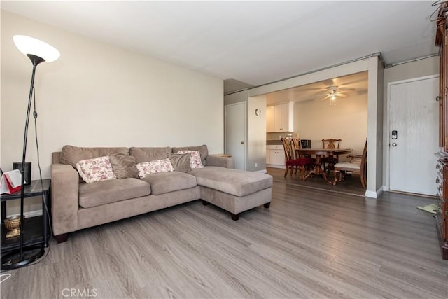 living room with wood-type flooring and ceiling fan