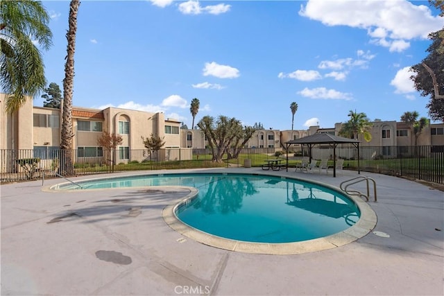 community pool with a residential view, fence, a patio, and a gazebo