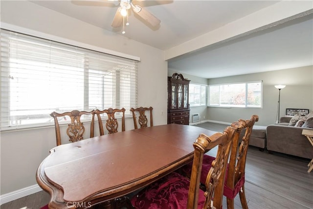 dining space featuring a ceiling fan, an AC wall unit, baseboards, and wood finished floors