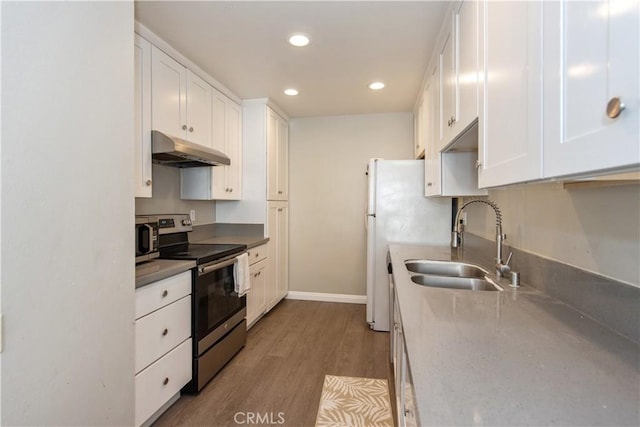 kitchen with appliances with stainless steel finishes, white cabinets, a sink, and under cabinet range hood