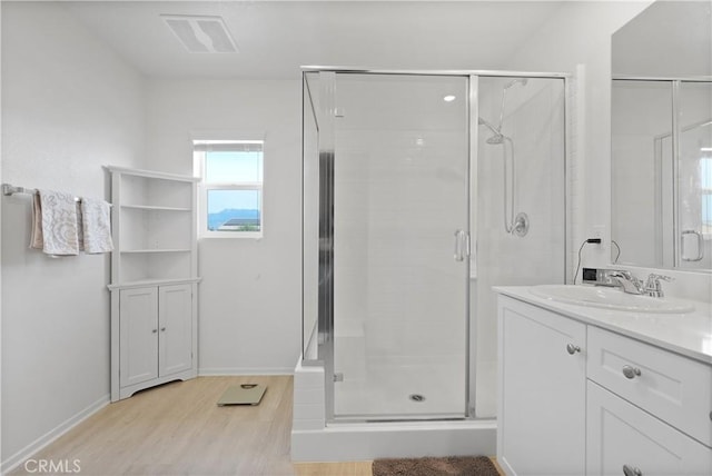 bathroom featuring hardwood / wood-style floors, vanity, and a shower with shower door