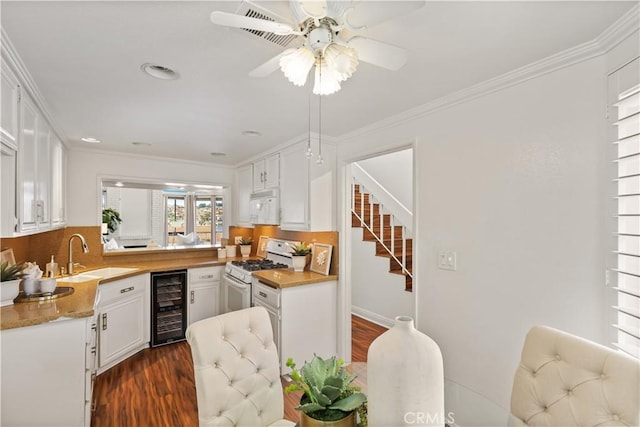 kitchen with white appliances, dark wood-type flooring, white cabinets, sink, and wine cooler