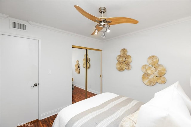 bedroom with ceiling fan, a closet, dark hardwood / wood-style floors, and ornamental molding