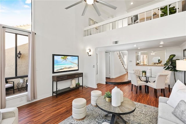 living room with dark hardwood / wood-style floors, high vaulted ceiling, ceiling fan, and ornamental molding