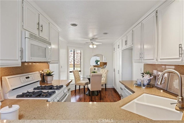 kitchen with white appliances, sink, dark hardwood / wood-style floors, ceiling fan, and white cabinetry