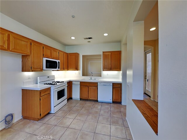 kitchen with light tile patterned floors, sink, and white appliances