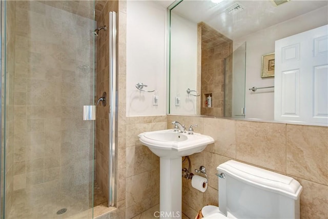 bathroom with an enclosed shower, decorative backsplash, toilet, and tile walls