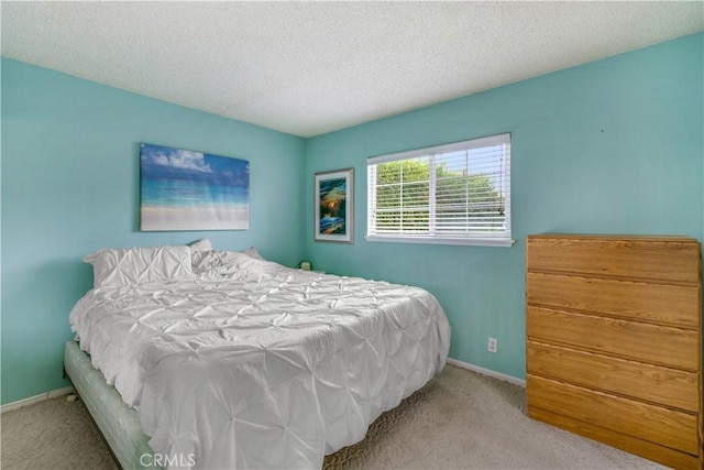 bedroom featuring light colored carpet and a textured ceiling