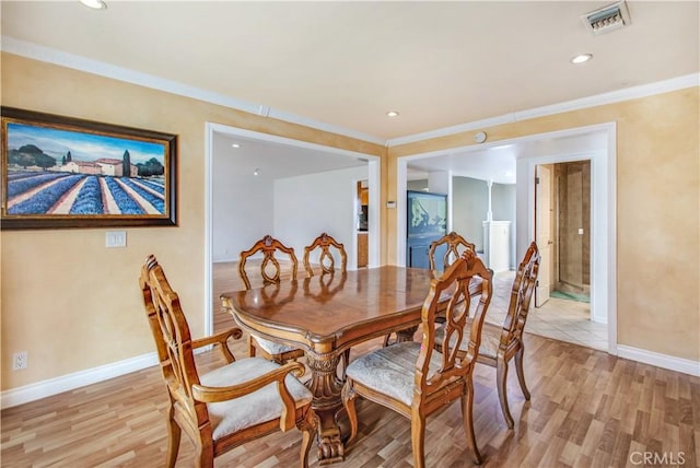 dining area featuring light hardwood / wood-style floors and crown molding