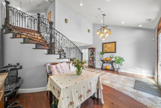 dining area featuring dark wood-type flooring and an inviting chandelier